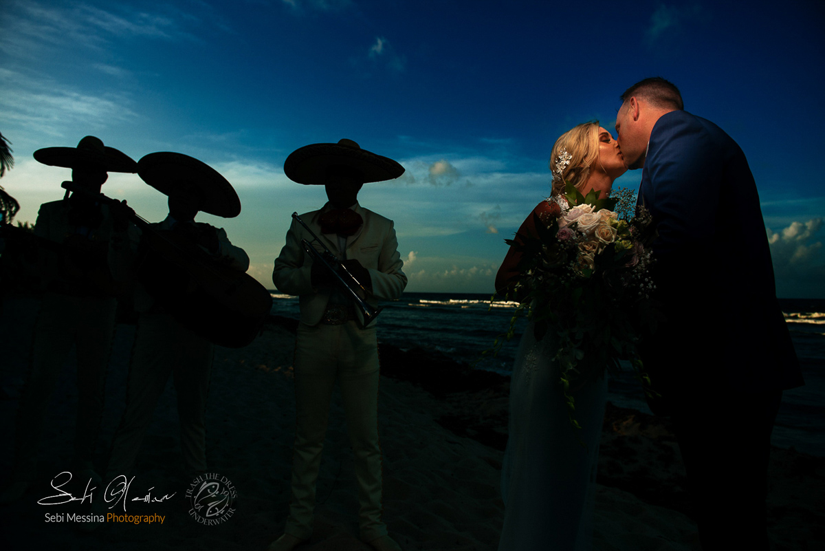 Just married couple on a Mexican beach with mariachi backlight