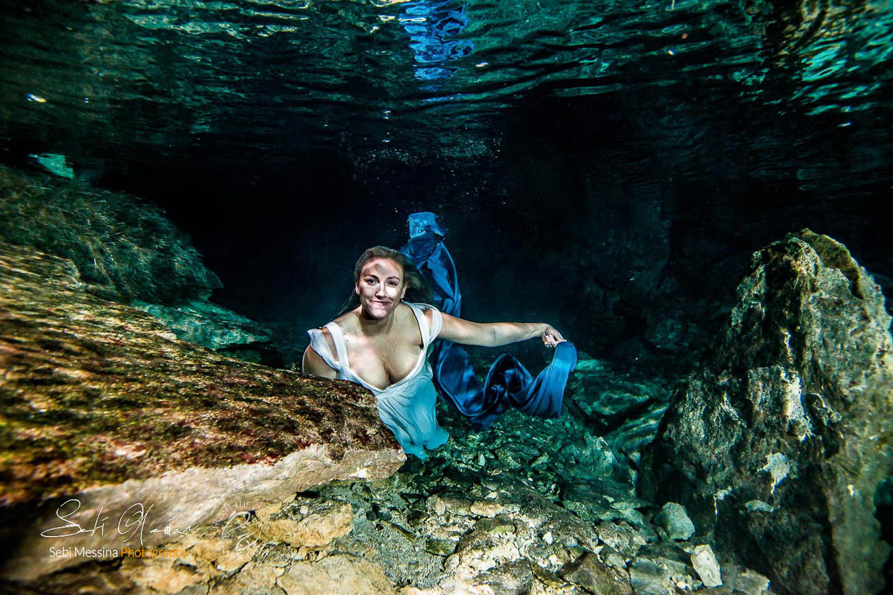 Bride with a blue fabric, while modelling underwater in a cenote in Mexico - Sebi Messina Photography