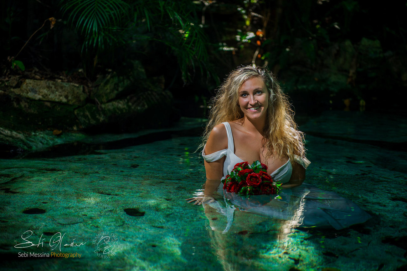 Beautiful bride sitting on the bottom of a cenote in Mexico