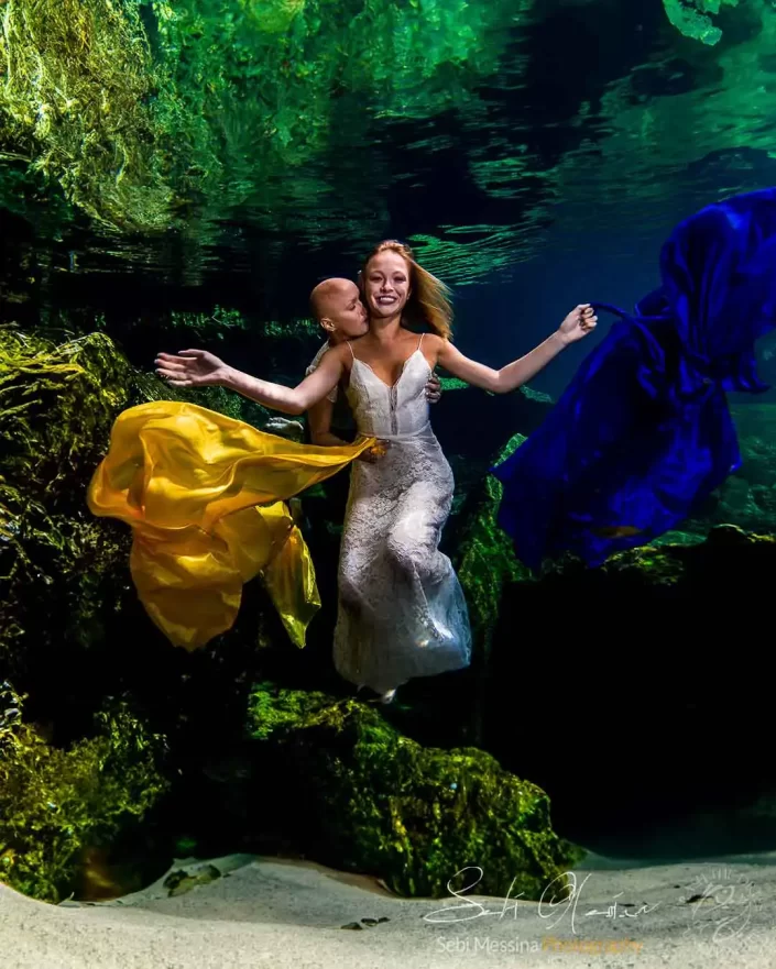 Underwater Photographer in Playa del Carmen – Cenote Trash The Dress same-sex Couple with Yellow and Blue Fabrics