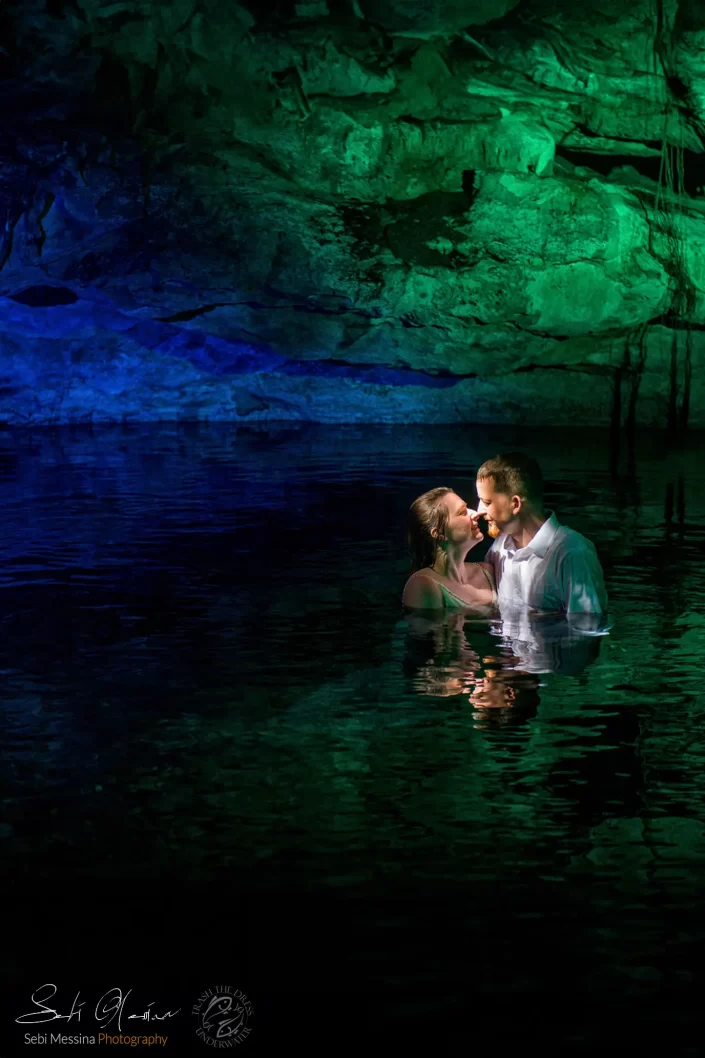 Bride and groom embracing in Cenote El Buho water with the cavern backdrop, Riviera Maya, for a romantic Trash the Dress session.